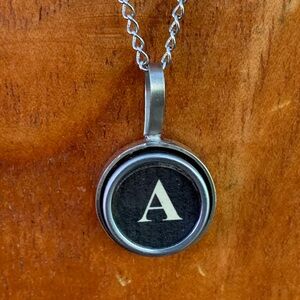 A vintage typewriter key initial pendant